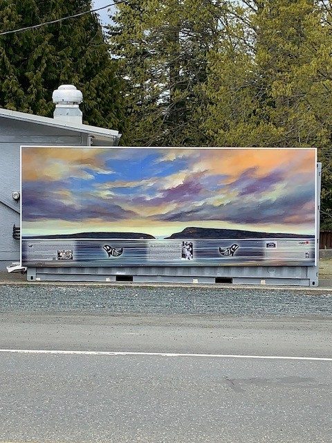 A sunset painted along the side of a storage container, with islands on the horizon.